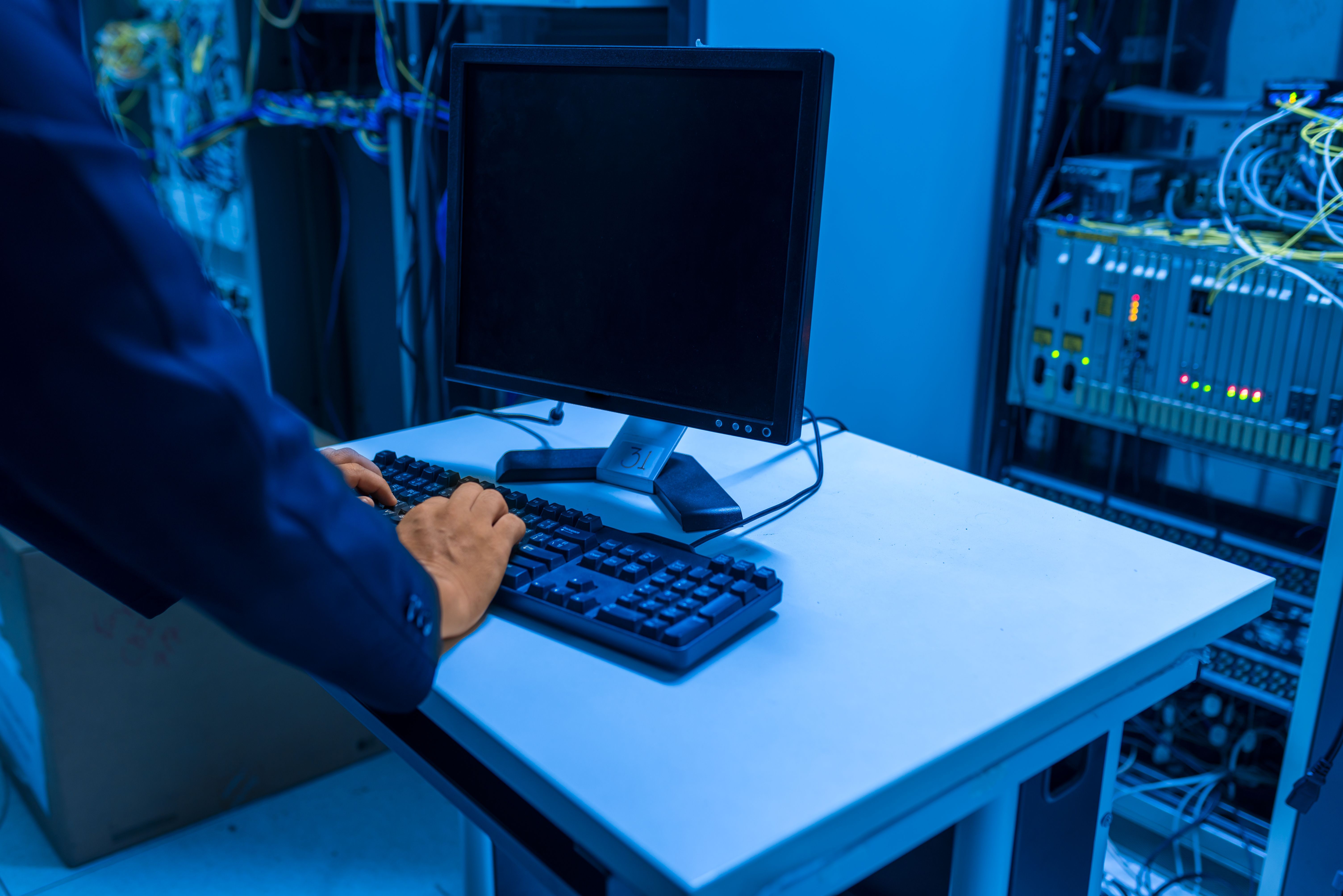 Technicien devant un poste de supervision dans une salle serveurs